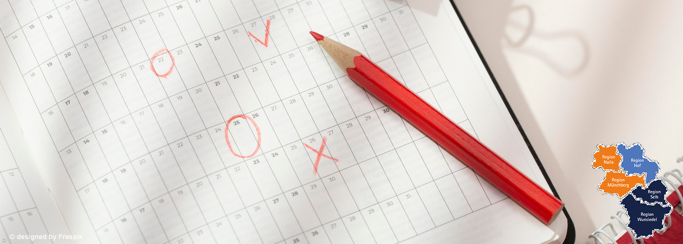 Roter Buntstift liegt auf einem Kalenderblatt