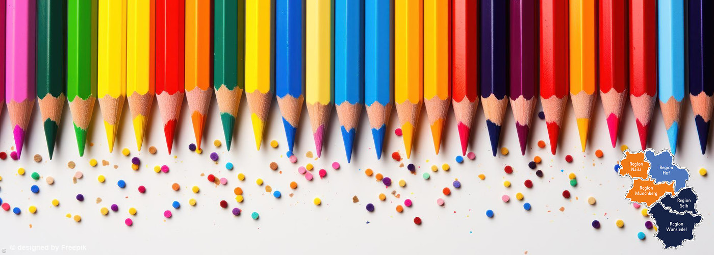 Reihe bunter Buntstifte mit angespitzten Spitzen und verstreuten Farbstückchen darunter